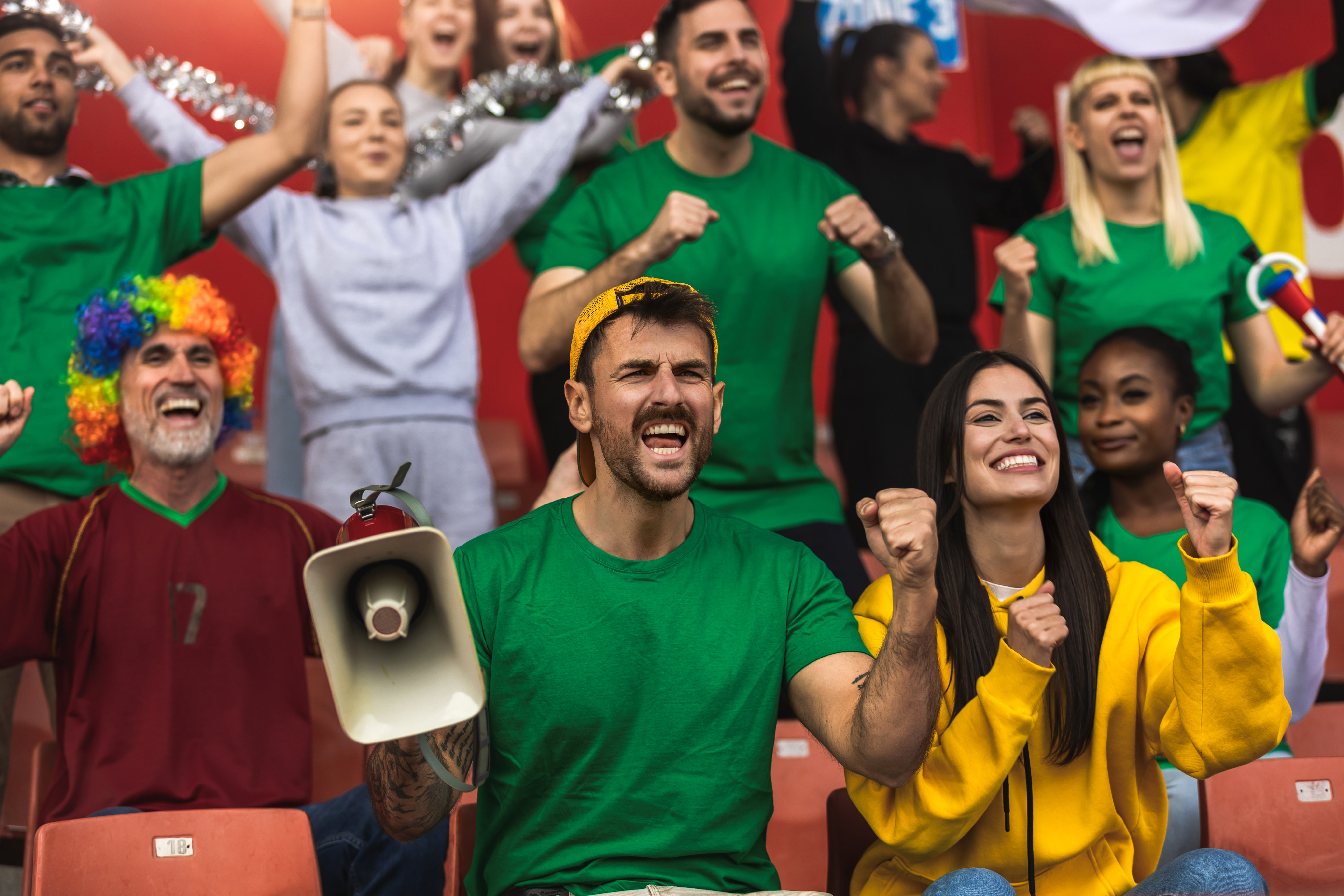 Soccer fans cheering for their team inside a packed stadium